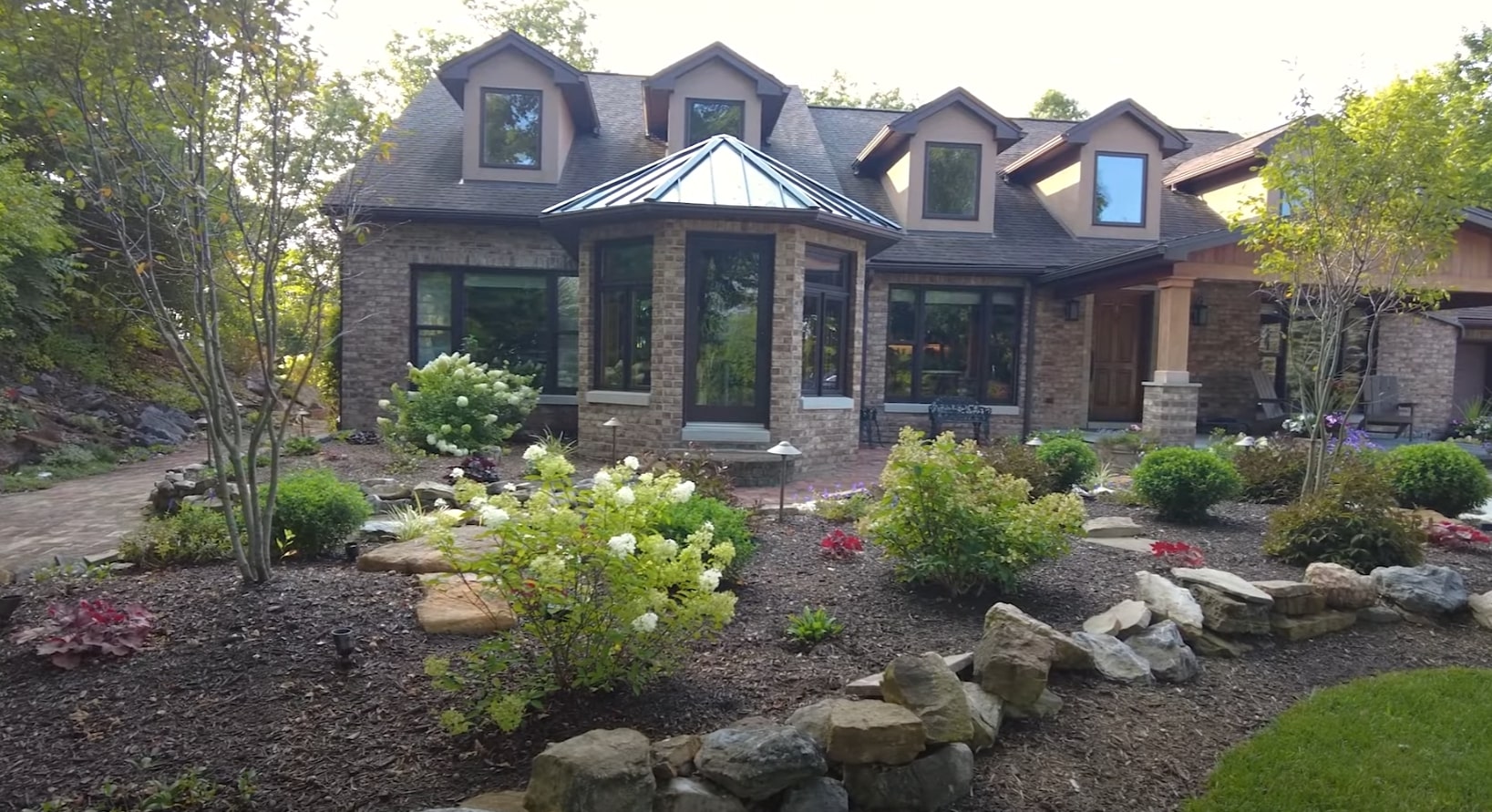 Maywood Landscaping Portfolio - Professional Residential Landscape Design and Installation Beautiful residential landscape featuring stone architecture, mature plantings, and professional design elements