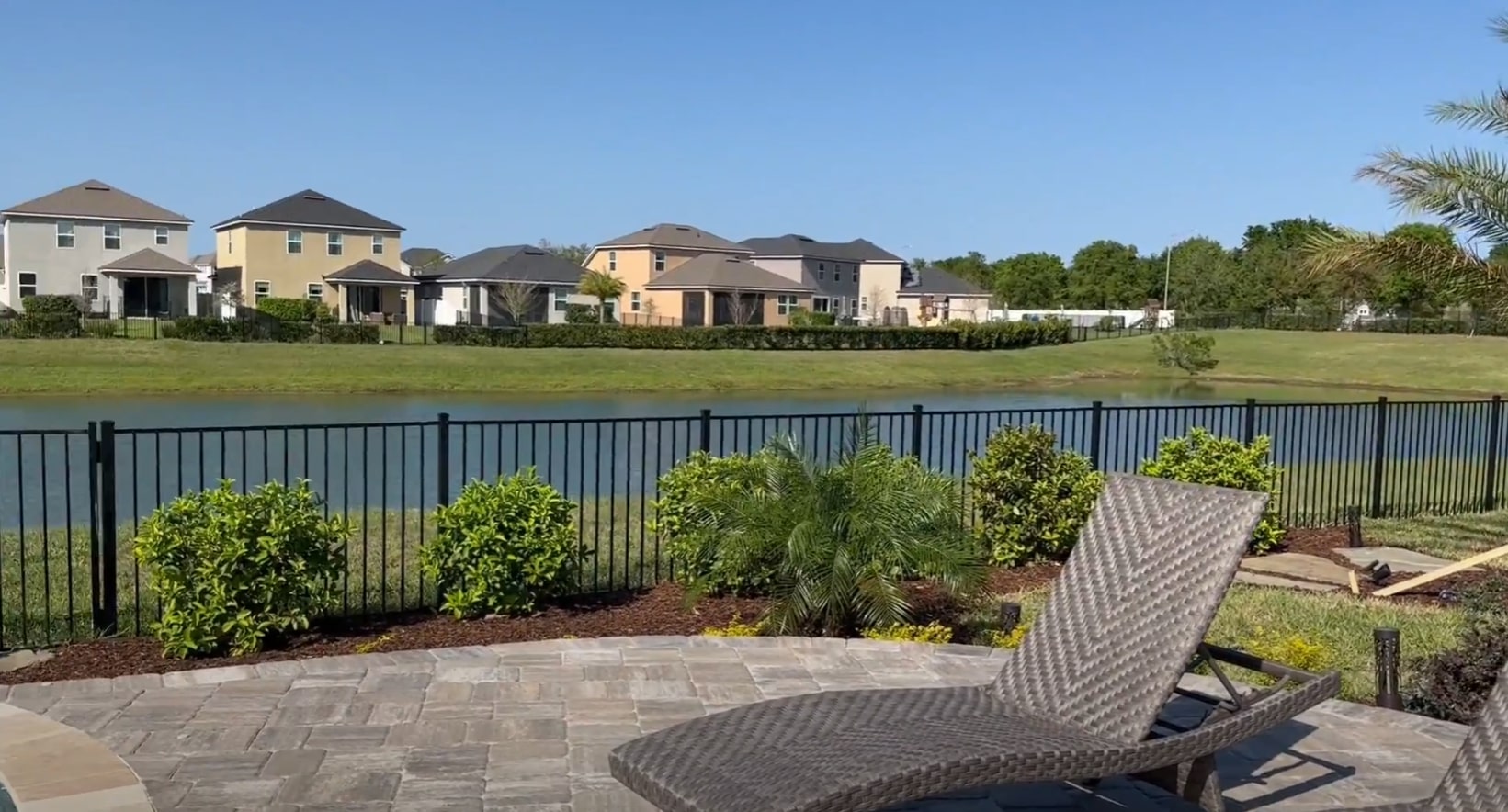 Completed Residential Landscaping Project - Lakefront Property with Professional Design and Installation Lakefront residential property with professional landscaping, privacy fencing, and outdoor furniture showcasing completed landscape project